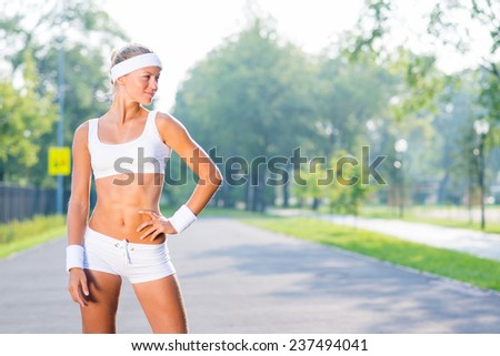 Young sport woman standing in sunny park