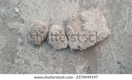 Stones from fractures of the mixture of cement and sand. They come from broken surface of parking lot with some possible causes like rain, dry, flood, wet and payload. These three are the biggest ones Royalty-Free Stock Photo #2374949197