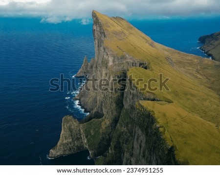 Foggy mountain peaks and clouds covering sea and mountains. Panoramical view from famous place - Sornfelli on Streymoy island, Faroe islands, Denmark. Landscape photography