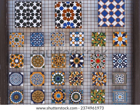 Mass produced souvenirs hanging on the wall. Various ornate magnetic plates, with images of Spanish Azulejo. Colorful ceramic tiles are sold on the street in Ronda, Spain.