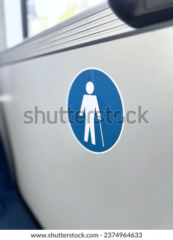 A sign on the bus wall indicating a priority seat for disabled people, a subway seat for an elderly person, giving way Public transport courtesy, Priority for elderly, Respectful seating, Give up your