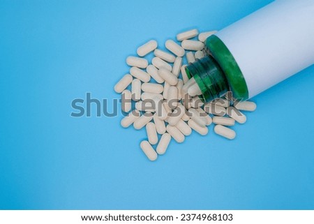 Medical pills on a blue background, selective focus, copy space