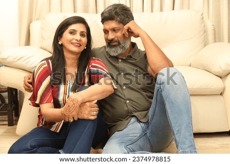 Happy Middle Aged Couple posing on Sofa At Home.  happy moment, harmonic relationships, love making care and enjoying weekend time together, copy space. Romantic couple enjoy weekend in new house. 