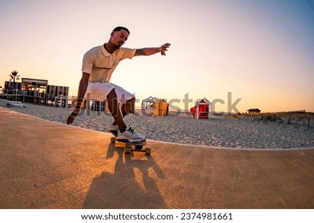 Surf skater training surfing moves near the beach at sunset. Royalty-Free Stock Photo #2374981661