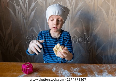 Boy making dough on the table with his hands