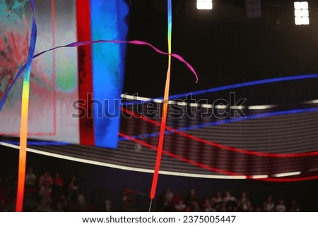 multi-colored ribbon for rhythmic gymnastics flies on a black background with spotlights