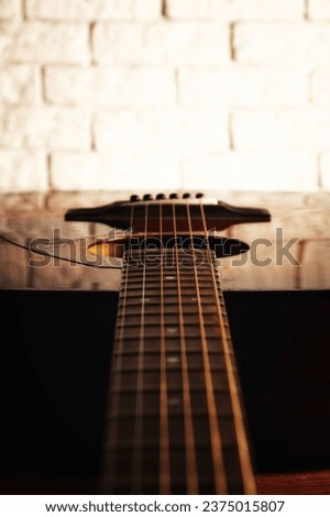 Dark toned perspective view of acoustic guitar frets and string in the interior. Musical instruments and music theme