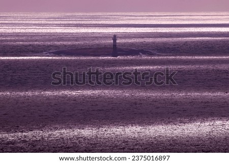 Beautiful view and sea scape over a  striped Skagerrak Sea, a light house and islands along the coast line. Cloudy skies causing the sun to highlight areas on the sea level. Royalty-Free Stock Photo #2375016897