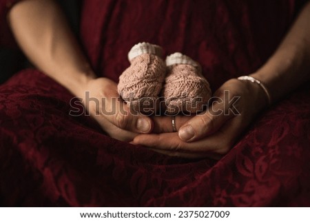 hands holding baby shoes pregnancy.jpg Royalty-Free Stock Photo #2375027009