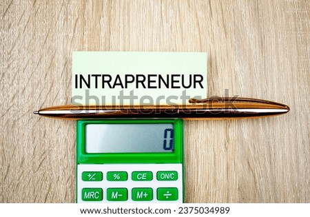 INTRAPRENEUR word, text on a notepad next to the calculator. Intrapreneur concept.