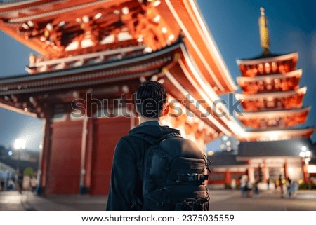 Selective focus of concentrated unrecognizable Hispanic male tourist standing on street near Japanese Sensoji temple in evening and while traveling in Asakusa Tokyo, Japan Royalty-Free Stock Photo #2375035559