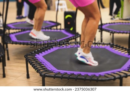 Trampoline fitness jumping training, group of young fit women in sportswear jump on trampolines, girls training with coach instructor, exercising on rebounder at the gym, mini trampoline workout Royalty-Free Stock Photo #2375036307