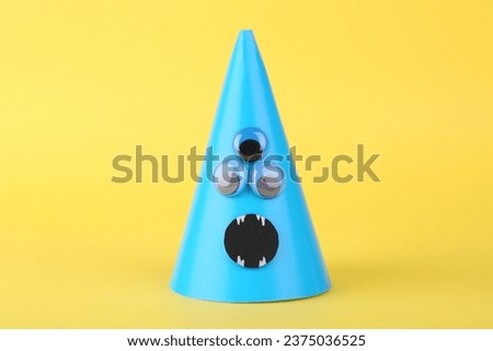Spooky paper monster on yellow background. Halloween decoration