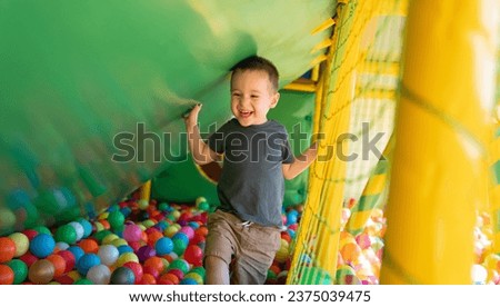 Happy smiling toddler boy playing in children's playroom. Active lifestyle, childhood. Selective focus Royalty-Free Stock Photo #2375039475