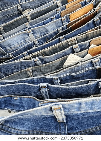 "CLOSED UP JEANS". The picture shows an arrangement of jeans of various colors and patterns shot close up.