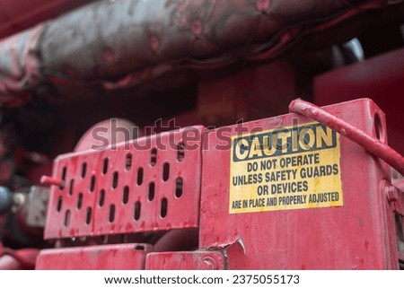 Caution safety sign of moving part inside the machine, dangerous for hand and finger injury. Industrial equipment safety information, close-up.