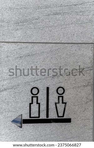 Men's and women's restroom signs in commercial buildings and directional arrows