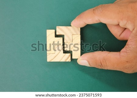 Puzzles are arranged and hands hold the last puzzle to combine. solution concept. concept of coalition or team Royalty-Free Stock Photo #2375071593