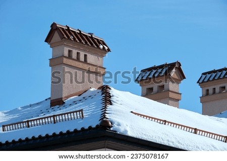 Closeup of house roof top covered with snow in cold winter. Tiled covering of building in wintertime weather Royalty-Free Stock Photo #2375078167