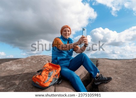 Woman reaching the destination and taking selfie, photos, and shouting on the top of mountain Travel Lifestyle concept The national park Peak District in England