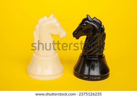Selective view of knight chess moving toward for battle with yellow cover background. Strategy and tactic concept.