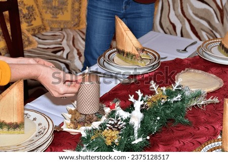 Lighting a Christmas candle on the Christmas table