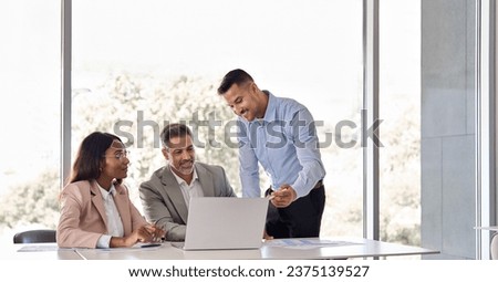 Happy business people executive team working at laptop using computer having discussion at office professional meeting showing financial project results consulting client investor at workplace. Royalty-Free Stock Photo #2375139527