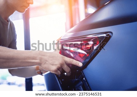 Replacing spare parts on a disassembled car in a car service garage Royalty-Free Stock Photo #2375146531