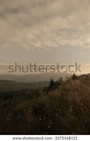 Sark silhouettes of distant mountains and a trees, Mountain meadow, sunrise, nature, foggy sky Royalty-Free Stock Photo #2375168121