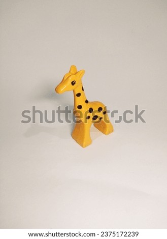 a plastic toy giraffe isolated on a white background.