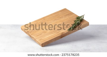 Cutting board falling on a grey stone table. Isolated on a white background. Culinary background. Empty wooden cutting board, product display space. Royalty-Free Stock Photo #2375178235