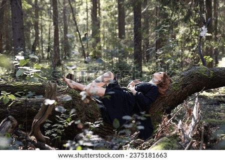 Forest girl resting on a tree. High quality photo