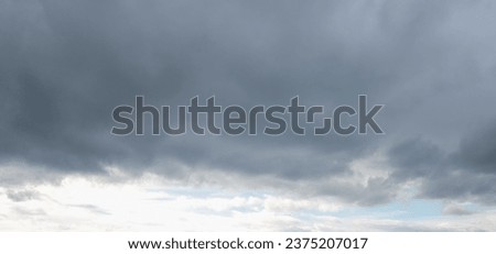 Autumn brings overcast skies adorned with gray stratus clouds, hinting at impending rain. This full-screen view provides ample space for text or design elements, making it perfect for various projects Royalty-Free Stock Photo #2375207017