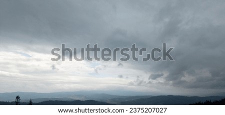 Autumn brings overcast skies adorned with gray stratus clouds, hinting at impending rain. This full-screen view provides ample space for text or design elements, making it perfect for various projects Royalty-Free Stock Photo #2375207027