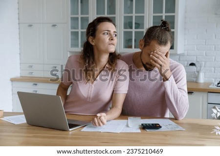 Worried young millennial husband and wife counting overspend budget, doing unpleasant paperwork, finding financial problems, high insurance, mortgage fees, bad loan conditions, bankruptcy Royalty-Free Stock Photo #2375210469