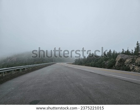 An open road heading into a foggy area.