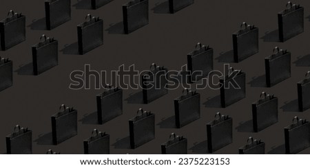 Pattern made from black paper shopping bags on black background. Black friday banner sale, shopping concept.. Royalty-Free Stock Photo #2375223153