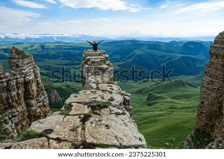 A girl on the background of the mountains and the Bermamyt plateau in Russia. June Royalty-Free Stock Photo #2375225301
