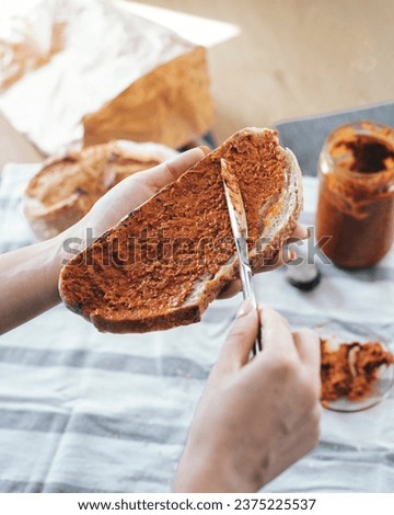 Bread slicing and spreading pepper spread. Traditional balkan food. Ayvar spread Royalty-Free Stock Photo #2375225537