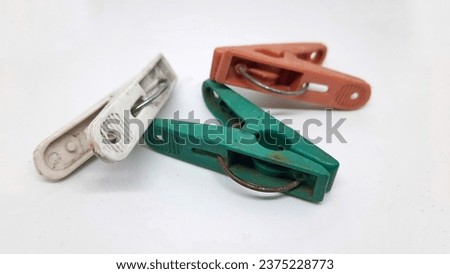 An image of colorful clothespins with rusty wire and faded colors isolated on a white background. Selective focus. Closeup
