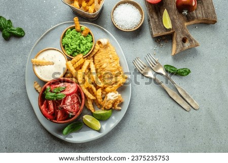 Crispy Fish and Chips served with mashed peas, vegetable salad, tartar sauce, Traditional British food, place for text, top view,