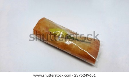 An image of a traditional Indonesian snack known as Lumpia containing minced chicken and carrots isolated on a white background. Selective focus. Closeup
