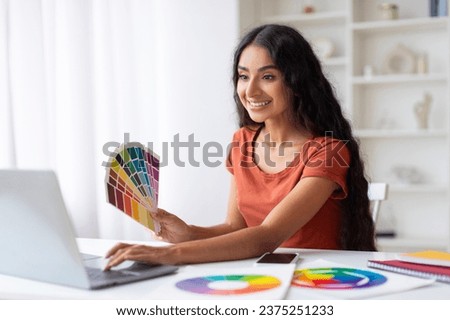 Indian Woman Freelance Graphic Designer Working With Laptop And Color Swatches At Desk In Home Office, Smiling Young Eastern Lady Choosing Color Gamma For New Design Project, Free Space
