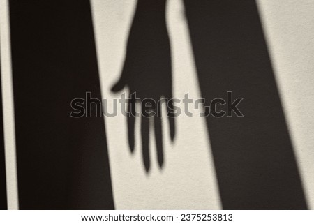 an abstract image of a shadow of a hand on a white wall