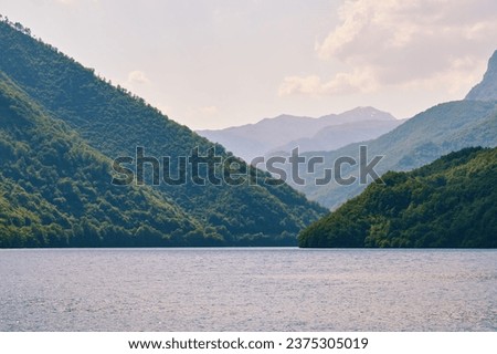 Calm tranquil lake water in the canyon between green mountains. Beautiful nature landscapes. Montenegro
