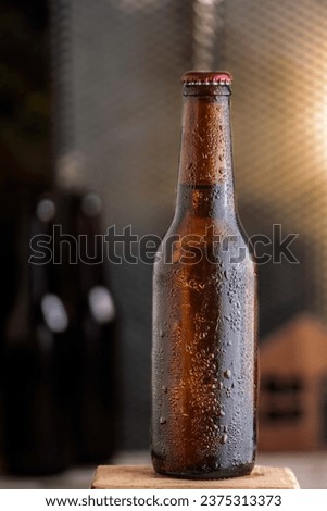 Cold beer bottle on wooden table with selective focus