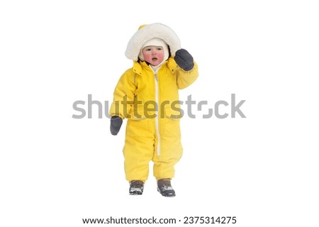 Portrait of a toddler baby in warm yellow clothes on a winter playground, isolated on white background. Happy baby boy in snowsuit standing in the snow in kindergarten. Kid age one year eight months Royalty-Free Stock Photo #2375314275