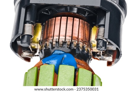 Commutator inside of electric DC motor part isolated on white background. Closeup of power machine rotor carbon brushes, coil springs and copper wire winding fixed by blue paste in black plastic case. Royalty-Free Stock Photo #2375350031