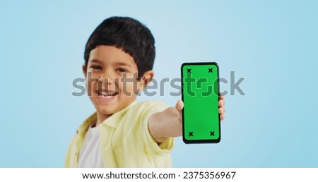 Kid, face or phone green screen in studio on social media for ecommerce, tech or download app logo. Blue background, space or happy child with notification for online marketing, mockup or advertising