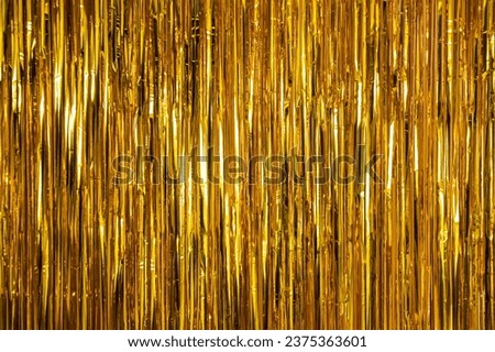Metallic gold foil tinsel fringe decoration curtain. Birthday, wedding, Christmas, New Year party decoration background. Party decor. Royalty-Free Stock Photo #2375363601